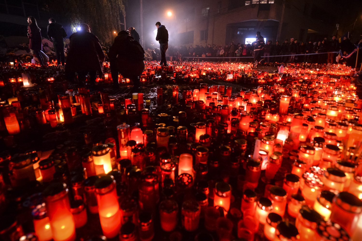 Persoane ce au participat la un mars al tacerii, aprind candele in memoria celor decedati in incendiul din Clubul Colectiv din Capitala
